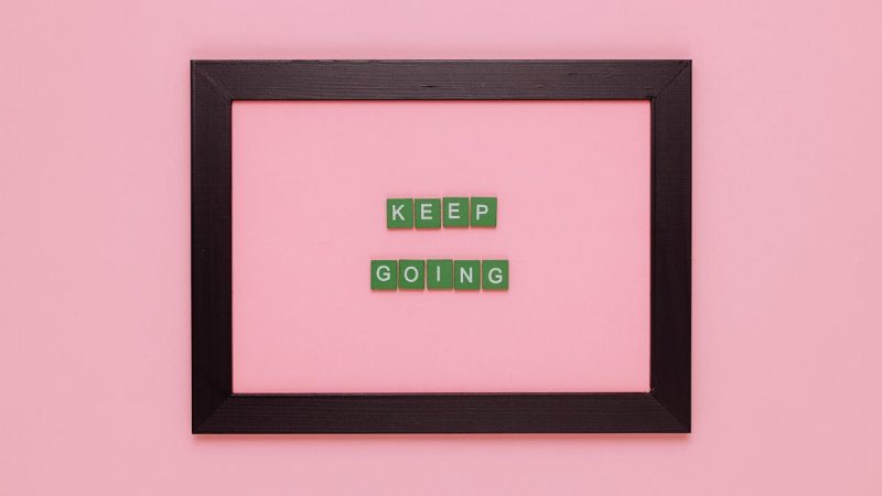 A framed motivational quote on a pink background for inspiration.