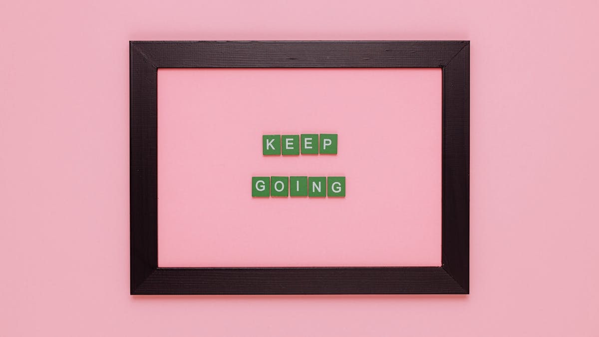 A framed motivational quote on a pink background for inspiration.